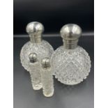 A Pair of silver topped scent bottles hallmarked for London 1892, makers mark GB, with two smaller