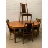 A Mid Century dining table with centre leaf and four chairs by Nathan