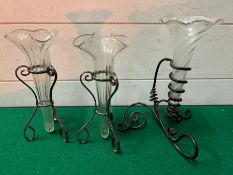 Three twisted glass bud vases in stands