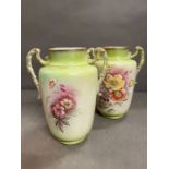 A pair of handpainted twin handle jugs or vases