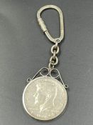 A silver key ring with inset 1964 American half dollar coin.