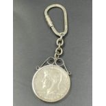 A silver key ring with inset 1964 American half dollar coin.