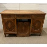 An oak desk with carved front and brass drop handles (H80cm W123cm D53cm)
