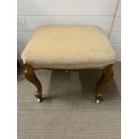 An upholstery stool on gilt legs