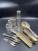 A selection of hallmarked silver vanity items to include glass jars, brushes, mirror etc all