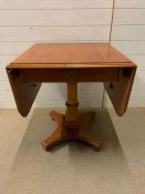 A drop sided side table with drawer to centre (Open W131cm H65cm)
