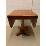 A drop sided side table with drawer to centre (Open W131cm H65cm)