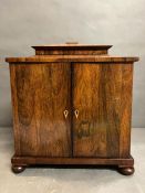 A Rosewood sarcophagus shape cabinet, two doors opening to velvet lined drawers with fitted interior