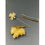 A 9ct gold shamrock brooch (1g) and two 9ct gold brooch fastners.