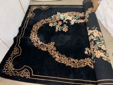 A substantial black ground rug with floral design and gold border (230cm wide)