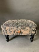 A fabric footstool with drawer.