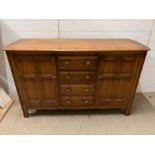 An Ercol sideboard with cupboards to side and drawers to centre