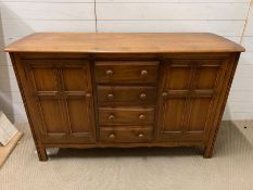 An Ercol sideboard with cupboards to side and drawers to centre