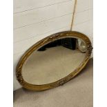 An oval gilt frame wall mirror