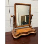 A dressing table mirror with carved arm supports