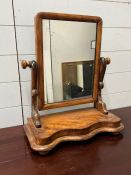 A dressing table mirror with carved arm supports