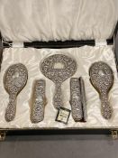 A silver backed dressing table set comprising brushes, comb and mirror in original box by W I