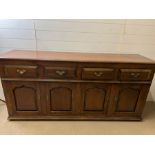 An oak sideboard with panelled doors and drawers above (H85cm W182cm D48cm)