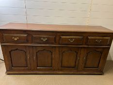 An oak sideboard with panelled doors and drawers above (H85cm W182cm D48cm)