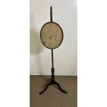 A George III style mahogany pole screen with floral silk work panel tripod base
