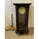 A mahogany wall clock with turn pillar supports to sides, key and weights