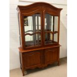 A glazed display cabinet with cupboard under on feet (H200cm W141cm D50cm)