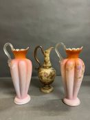 A pair of bohemian peach glass ewers, along with one other