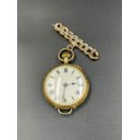 A Ladies 15 ct gold and enamel fob watch on a 9ct gold bar brooch with floral design.