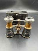 A pair of sportiere French binoculars made of chrome and brass with decorative case of running deer