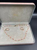 A coral and pearl necklace and earring set