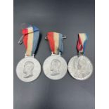 Two Empire Day aluminium medals and a King George V and Queen Mary silver jubilee medal.