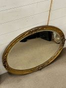 An oval gilt frame wall mirror