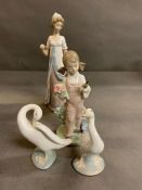 Four Lladro figurines, two swans, a lady in a gown and a little girl gardening