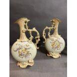 A pair of hand painted porcelain ewers