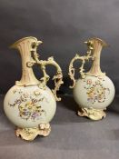 A pair of hand painted porcelain ewers
