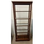 An open glass and mahogany shelving unit (H173cm W66cm D30cm)