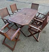 A six seater wooden garden table with folding chairs (H74cm W150cm D87cm)