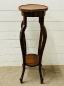 A lamp or plant stand on carved legs