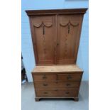 A pine two part cabinet with double doors opening to shelves and two over two chest of drawers below