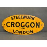 An oval enamel yellow sign, advertising a plumbing company