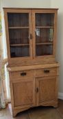 An antique pine dresser with double glazed doors on top of two drawers and cupboard under (H197cm
