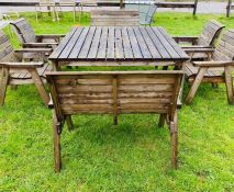 A large wooden slatted square table with four chairs and two seater benches