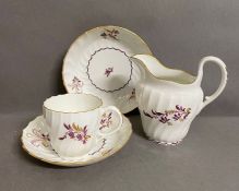 A Worcester coffee cup, saucer, milk jug and another saucer circa 1790 with puce floral sprays