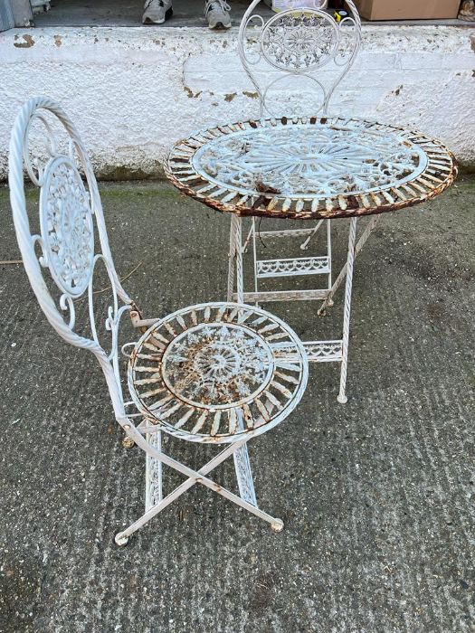 A white metal oval table, bistro set with two chairs