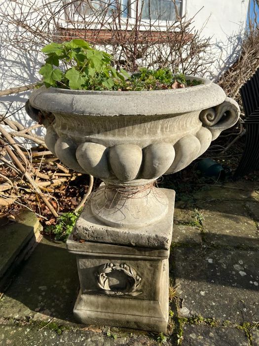 A pair of regency design composition stone campana shaped garden urns on plinth (80cm handle to