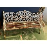 An architectural cast iron bench with vine pattern cast back, scrolling arms and iron slat seats,