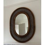 A cane and wicker oval wall mirror