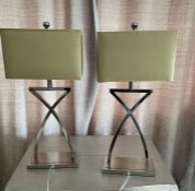 A pair of chrome table lamps with cross design