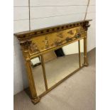 A regency style giltwood and gesso over mantle mirror with breakfront cornice with a relief