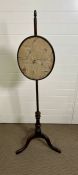 A George III style mahogany pole screen with floral silk work panel tripod base